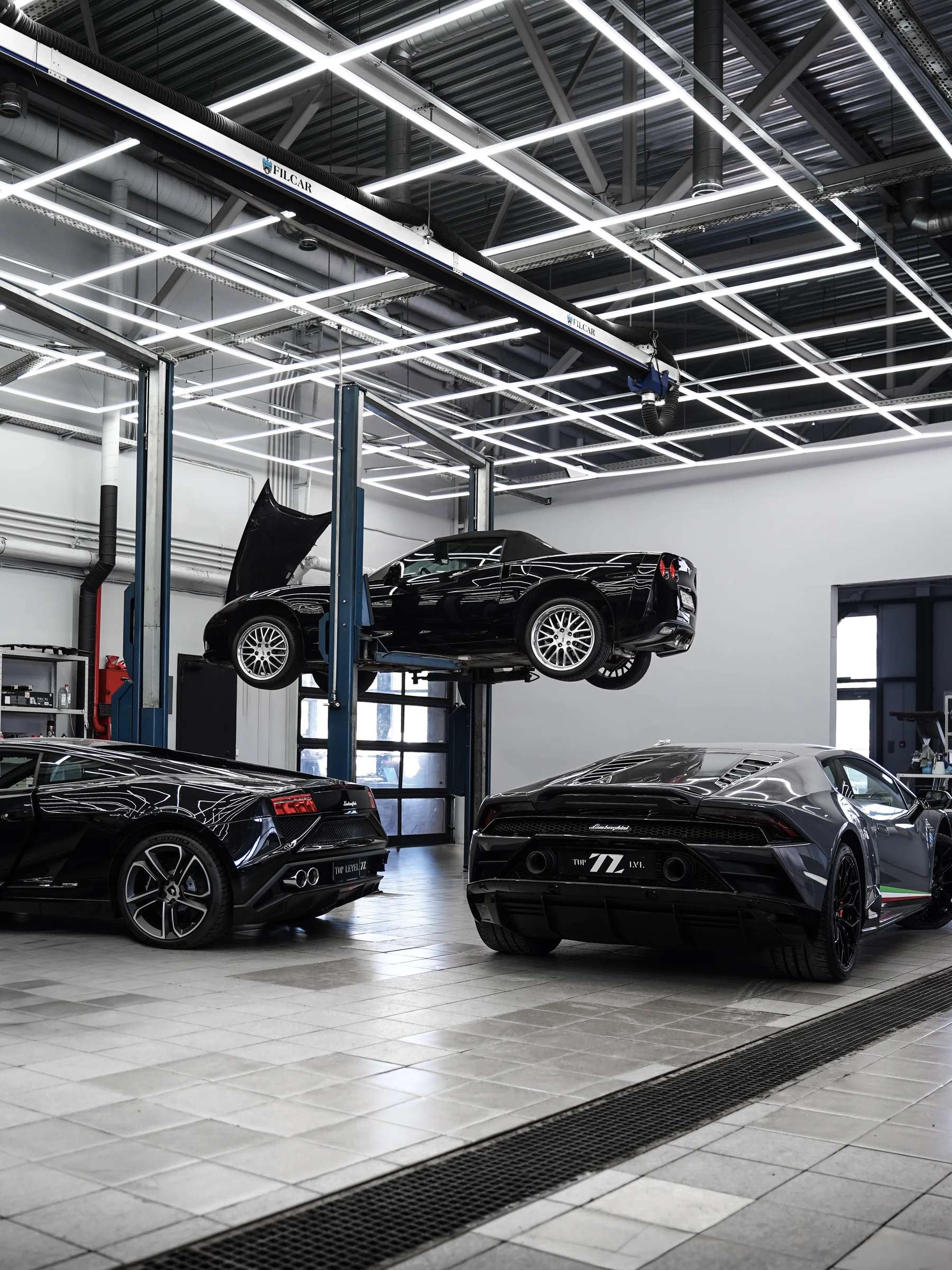 Chevrolet Corvette на подъёмнике рядом с Lamborghini Gallardo и Huracan